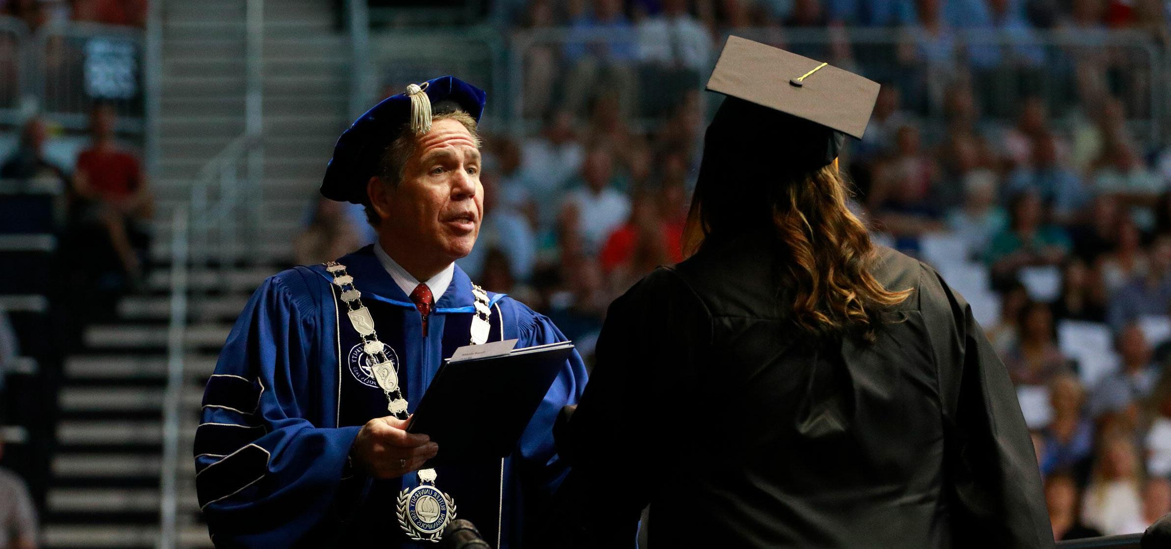 President 丹科 handing over diploma at commencement